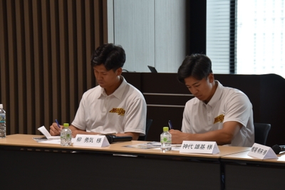 高橋さんのアドバイスを熱心にメモを取る硬式野球部員