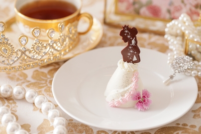 ▲プリンセスドレスケーキ イメージ ロイヤル ウエディングの主役である“プリ ンセス“をイメージした特別な一品。 優美な佇まいのプリンセスのドレス部分は、アーモンドムースといちごジュレの2層になっており、濃厚な甘みと爽やかな酸味が楽しめる。エディブルフラワーや銀粉でゴージャスなドレスのデティールを表現。