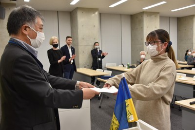 稲葉千晴教授(右)からボランティア・ガイドの認定証を受け取る山口ひかりさん