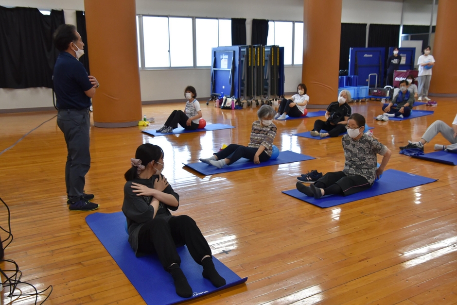 梅田教授(左)らが指導し、学生も一緒に運動