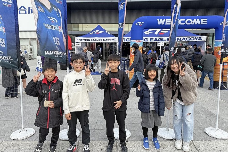試合会場の前でワクワクした様子で写真撮影をするQQキッズたちの様子