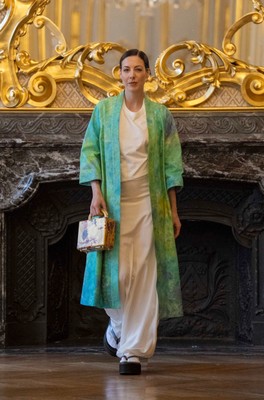 伊砂正幸氏の染色作品によるグリーンの羽織。ゴールドのボックス型バッグを手に