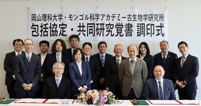 調印式後、記念写真に納まる出席者。最前列左側が平野学長、右側がバダムハタン所長