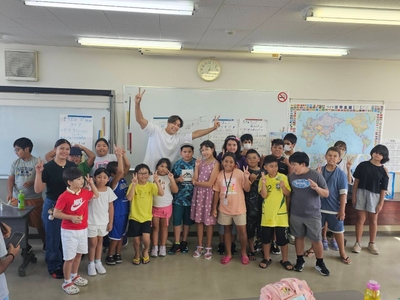 「日本語補修教室に通う子どもたちと笑顔で記念撮影する當間ローズ(湖西国際交流協会にて、2025年8月18日)」
