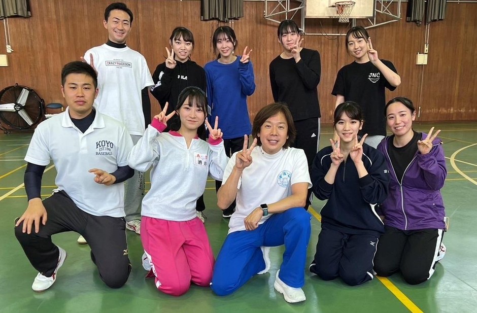 学生たちと写真に収まる佐藤特任教授(中央)