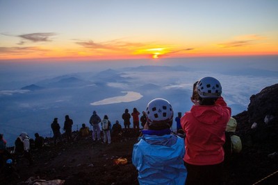 富士山頂でご来光を迎える学生たち