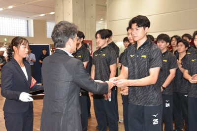 援助金を渡す校友会の矢野専務理事