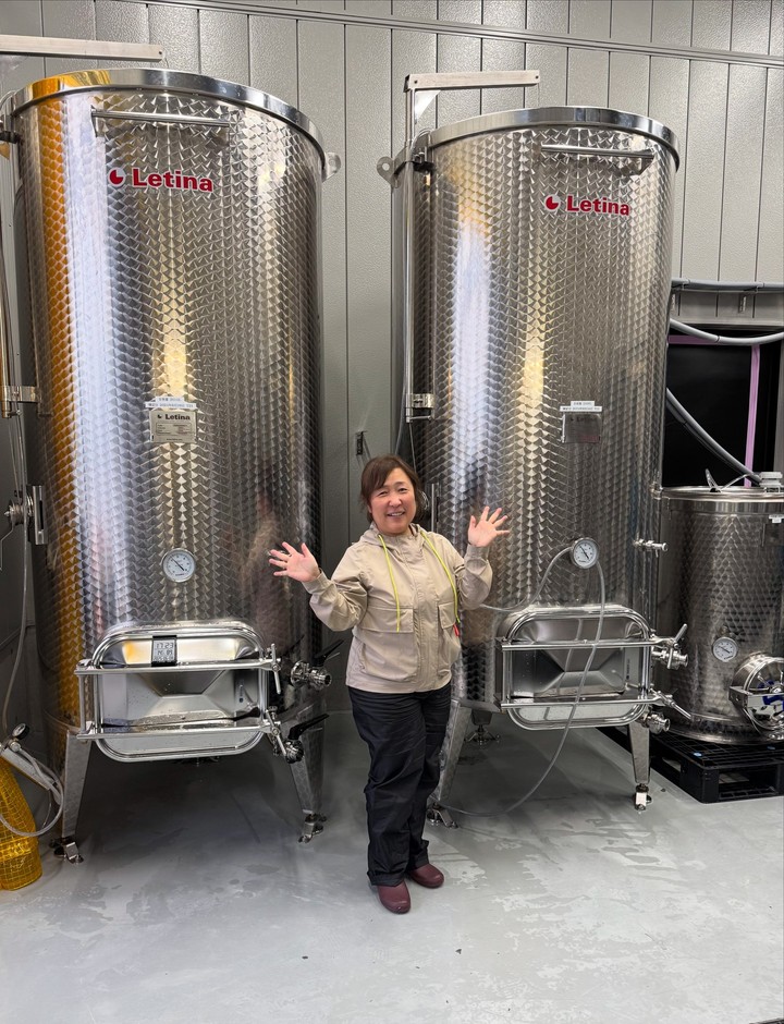 小さな身体での発酵管理は一苦労（醸造タンクの前で）