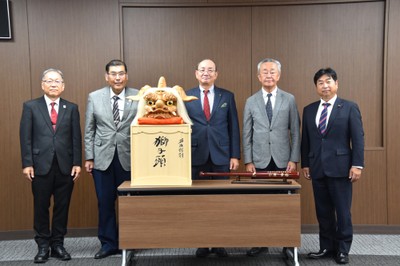 贈られた獅子頭を囲む（左から）野口学長、小原理事長、田中市長ら